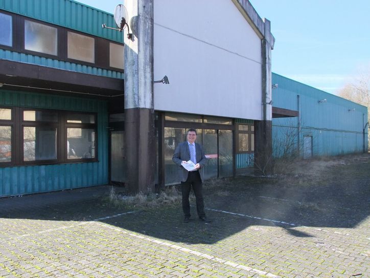Stadtbürgermeister Dr. Mathias Queck vor der verfallenen Immobilie, die früher den Hela-Fachmarkt beherbergte. Das Gebäude soll nun abgerissen werden und Platz schaffen für  ein neues Einkaufszentrum. Foto: Fischer