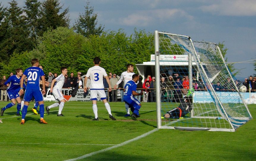 Das war der erste Streich der Karbacher: David Eberhardt (blaues Trikot ganz links) setzte den Ball mit einem wuchtigen Kopfball ins Netz der Emmelshausener. (Foto: Arno Boes)