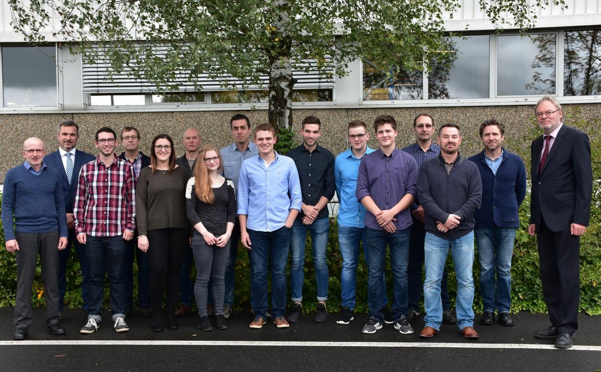 Geschäftsleiter Hartmut Fischer mit den erfolgreichen Absolventen und Gratulanten. Foto: Paula Sonnen