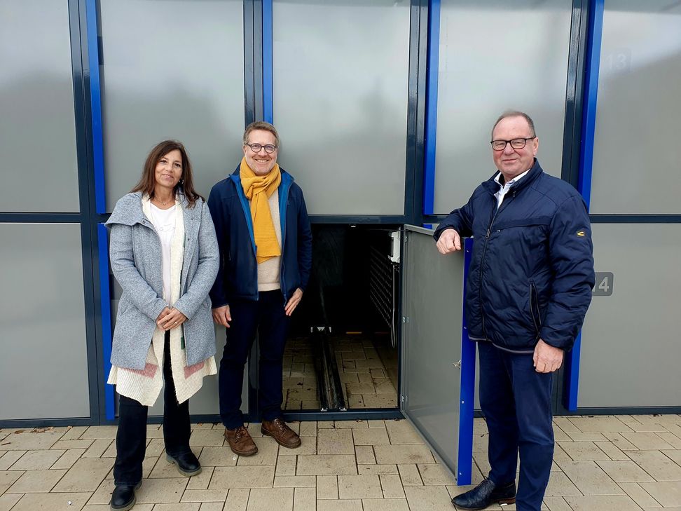 Sandra Mayer (Bauamt der VG Saarburg-Kell), Stadtbürgermeister Andreas Reymann und Bürgermeister Jürgen Dixius (VG Saarburg-Kell) vor der neuen Fahrradbox am Bahnhof.