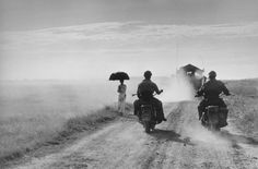 Capa Motorcyclists and woman walking on the road from Nam Dinh to Thai Binh Indochina (Vietnam) May 1954 (c) Robert Capa (c) International Center of Photography Magnum Photos