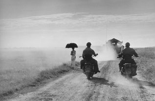 Capa Motorcyclists and woman walking on the road from Nam Dinh to Thai Binh Indochina (Vietnam) May 1954 (c) Robert Capa (c) International Center of Photography Magnum Photos