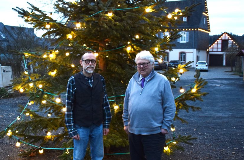 Der Weihnachtsbaum auf dem Vorplatz des Pfarrsaals steht bereits. Friedbert Christmann (l.) und Heribert Schmitz freuen sich auf Heilig Abend.