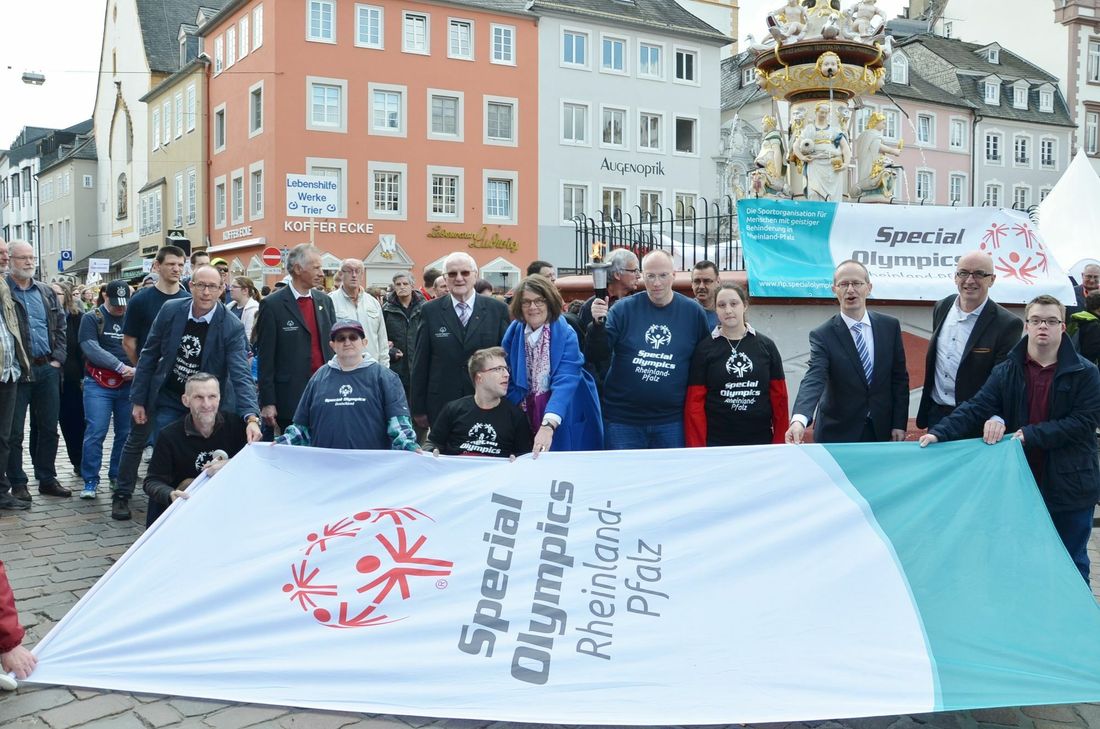 Bürgermeisterin Angelika Birk (M.), Special-Olympics-Ehrenpräsident Karl-Heinz Thommes (stehend, l. daneben) und die Botschafter Heinrich Waßenberg (mit Fackel) und Viviana Saltalamacia (r. daneben) anlässlich des symbolischen Fackellaufs im April 2016. Passend zum Event zeigt die Trier Galerie gemeinsam mit der Lebenshilfe Trier ab 12. Juni in einer Ausstellung im Kunst- und Kulturraum eigenART Fotos von Sportlern mit Handicap. Foto: Archiv