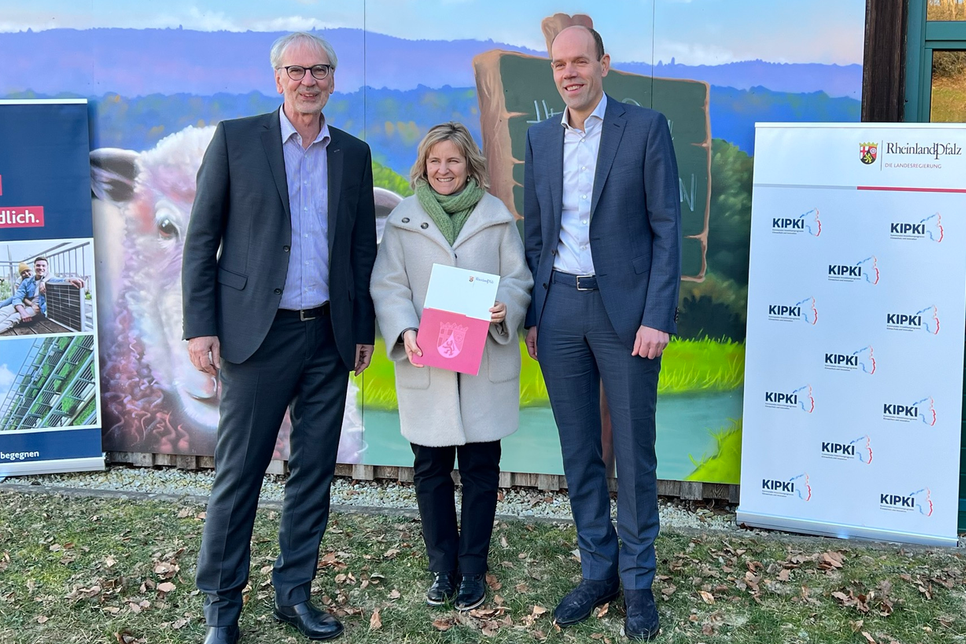 Klimaschutzministerin Katrin Eder (Mitte) überreicht den Förderbescheid an Landrat Volker Boch (links im Bild), der sich gemeinsam mit RHE-Vorstand Thomas Lorenz (rechts im Bild) über die 1,5 Millionen Euro hohe Zuwendung freut.