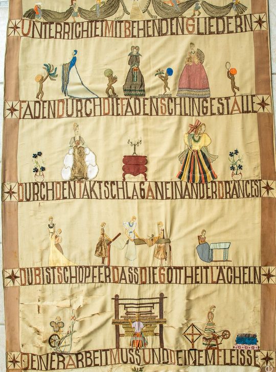 Der Wandteppich zeigt symbolhaft die Entstehung eines Gewandes.