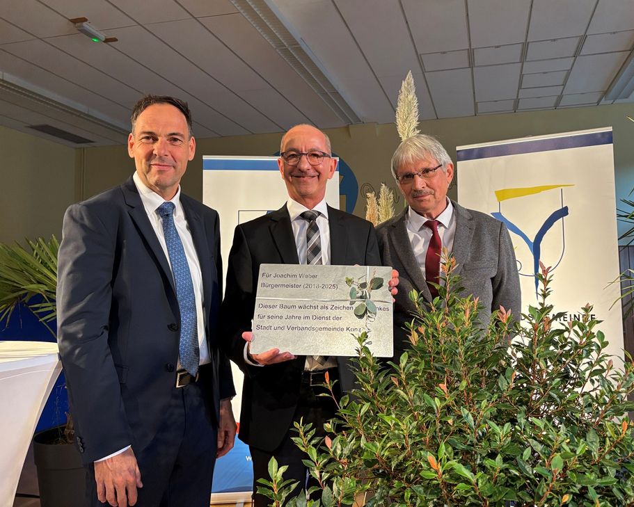Der neu ins Amt eingeführte Bürgermeister, Guido Wacht (links) mit dem 1. Beigeordneten der Stadt Konz, Bernhard Marx (rechts) bei der Geschenkübergabe an den ehemaligen Bürgermeister, Joachim Weber (Mitte).