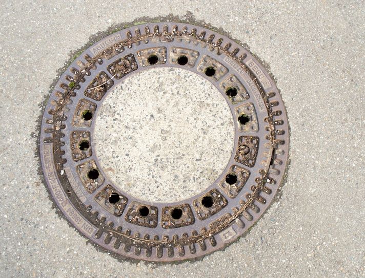 Ein Schneeräumfahrzeug ist in einen Kanalschacht gefahren, da der Kanaldeckel ausgehoben war.