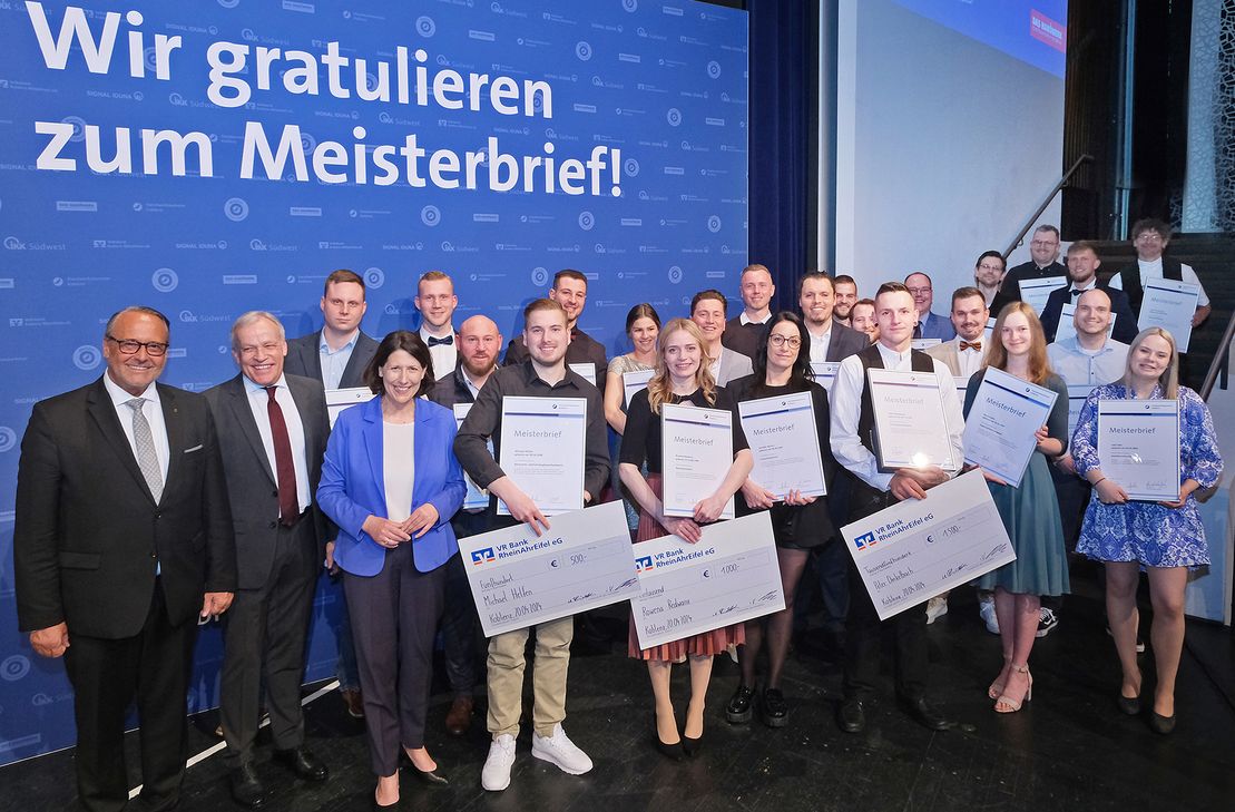 Die 23 Besten ihres Gewerkes erhielten aus Händen von HwK-Hauptgeschäftsführer Ralf Hellrich (vordere Reihe von links), Präsident Kurt Krautscheid und Wirtschaftsministerin Daniela Schmitt auf der Bühne ihre Großen Meisterbriefe. Das allerbeste aller 713 Prüfungsergebnisse erreichte Dachdeckermeister Peter Dinkelbach aus Asbach im Westerwald (vordere Reihe 3.v.r.).