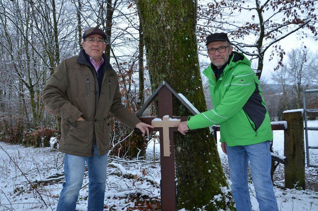 Gerd Küpper (l.) und Herbert Franzen vom Eifelverein Eicherscheid müssen immer wieder Vandalismus an Wegekreuzen, Flurnamen-Schildern, Bänken und Tischen rund um den Ort feststellen. Foto: T. Förster