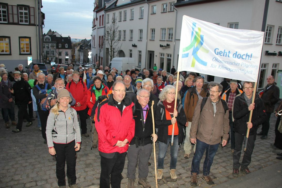 Bischof Stefan Ackermann (rote Regenjacke, links vorne) kommt gemeinsam mit den Pilgern an der Pfarrkirche St. Martin und Severus in Münstermaifeld an.