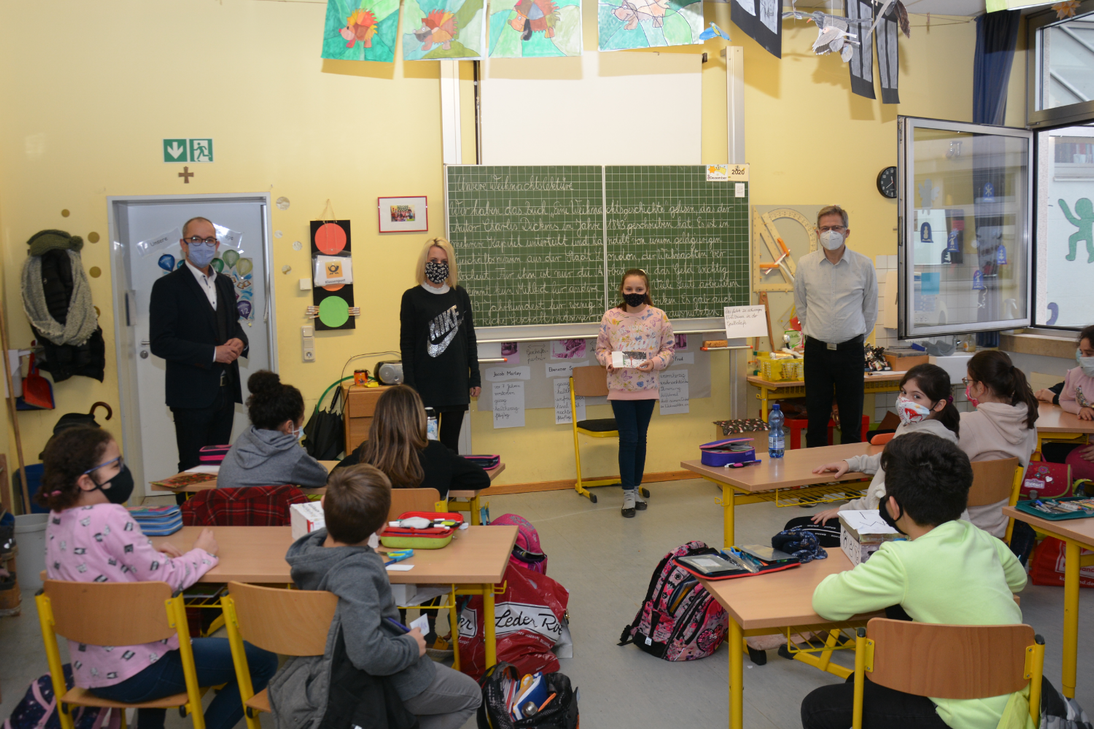 V.l.: Bürgermeister Weber, die Klassenlehrerin Nicole Roth, die Künstlerin Anna und Schulleiter Thomas Kürwitz vor der Klasse 4b der Grundschule St. Johann anlässlich des Schulbesuchs. Foto: Stadt Konz