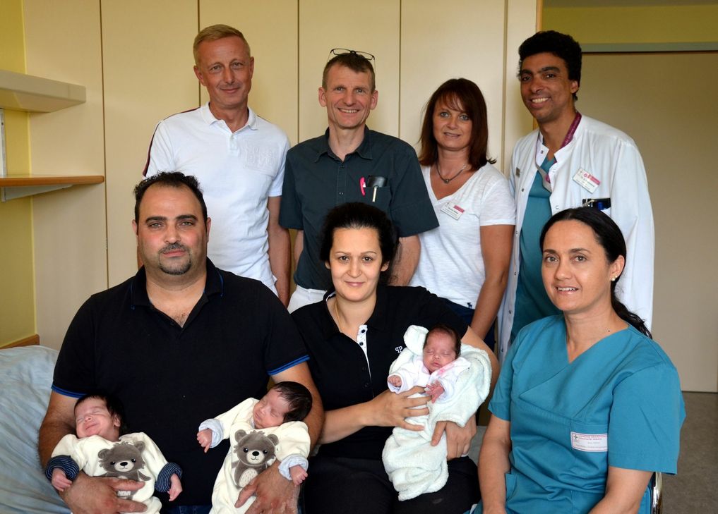 Dreifaches Babyglück: Unser Foto zeigt v. l. stehend: Die Chefärzte der Geburtshilfe und der Kinder- und Jugendmedizin, Dr. Michael Kumbartski und Dr. Christoph von Buch, Kerstin Weber von „Guter Start ins Kinderleben“ sowie den Leiter der Kinderintensivstation, Dr. Edmondo Hammond.