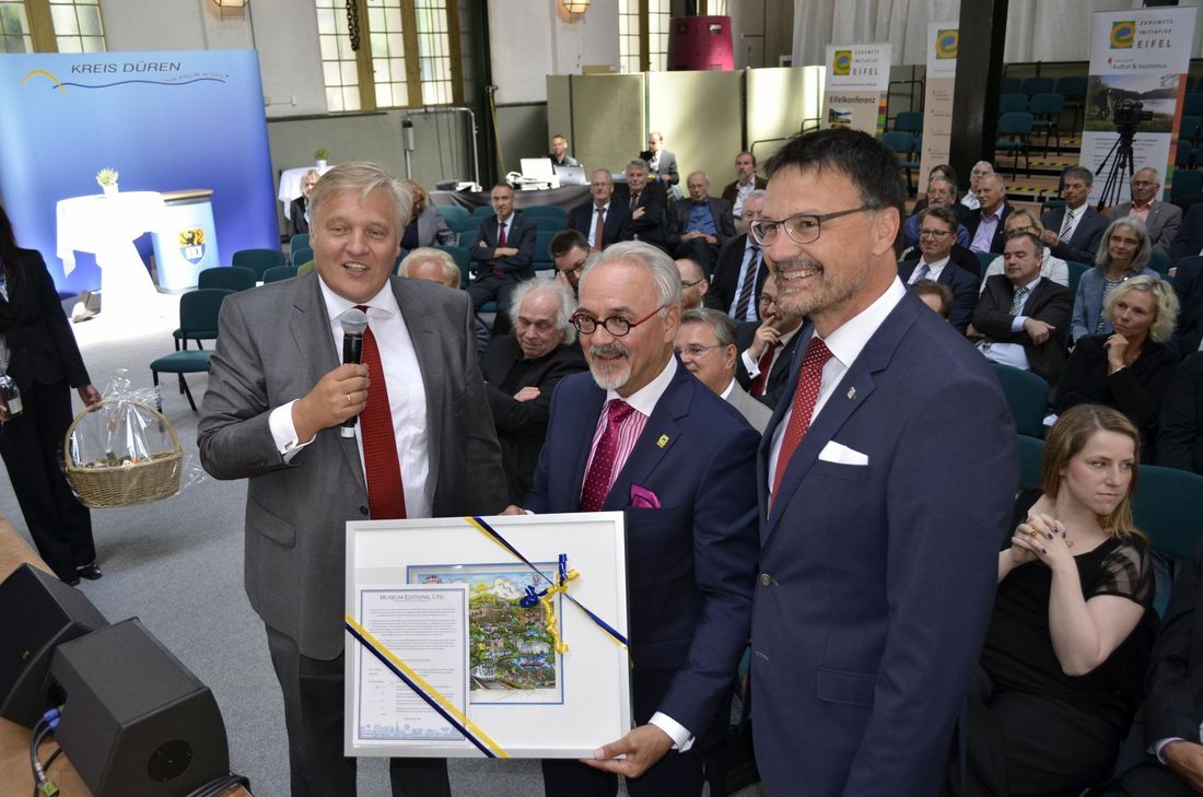 Ein Geschenk für Helmut Etschenberg: Der Dürener Landrat Wolfgang Spelthahn und Heinz-Peter Thiel, Landrat des Landkreises Vulkaneifel und derzeitiger Vorsitzender der Zukunftsinitiative Eifel, überreichten ihm ein Faccino-Bild.