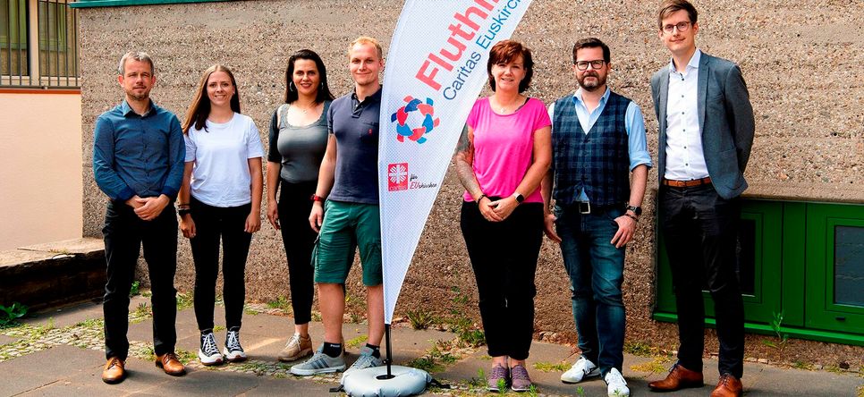 Martin Jost (v.li.; Vorstand Caritas Euskirchen), Saskia Reder, Elisa Mc Clellan, Tim Hennes, Doreen Zilske (Team Fluthilfe Caritas Euskirchen), Carsten Düppengießer (Öffentlichkeitsarbeit Caritas Euskirchen) und Matthias Schmitt (stellvertretender Diözesan-Caritasdirektor).