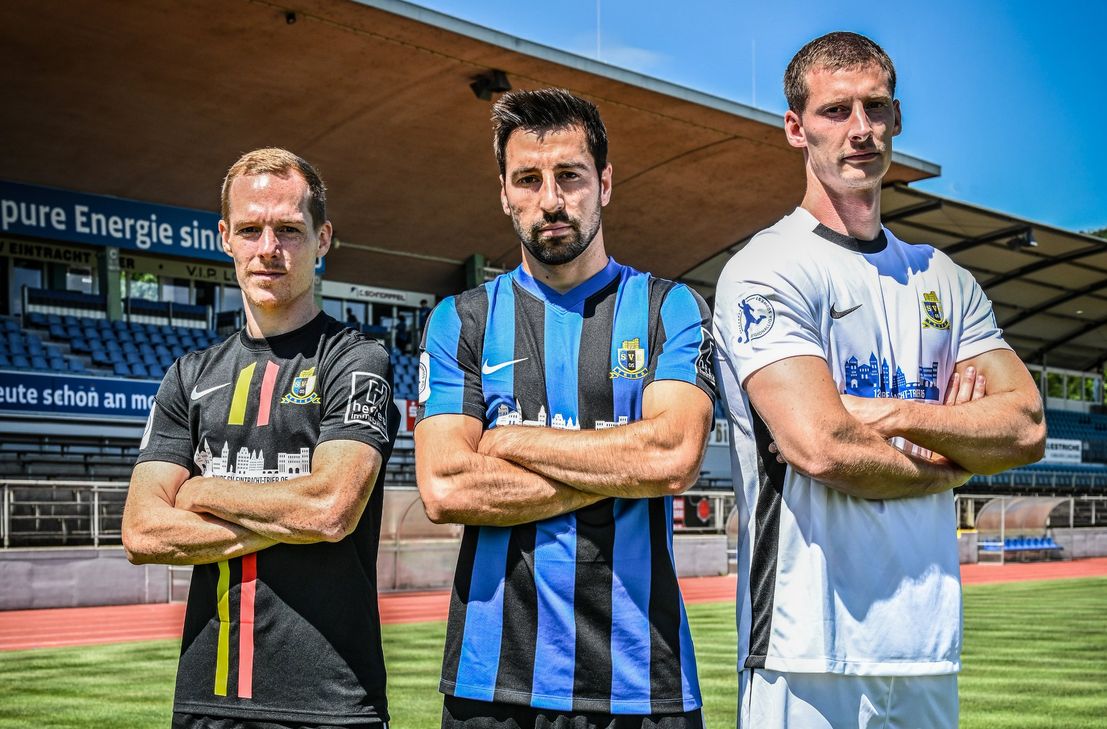 Von links nach rechts: Jan-Lucas Dorow (Offensives Mittelfeld), Christopher Spang (Defensives Mittelfeld) und Henri Weigelt (Innenverteidiger) mit den neuen Trikots auf dem Spielfeld im Moselstadion.