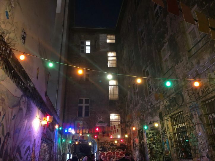 Über dem Lokal sind bunte Lichter. So kann man die Bilder an den Wänden, die von Künstlern gemacht sind, besondern gut sehen!