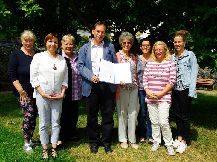Im Pfarrgarten in Hirzenach nahmen Sr. Dr. Lea Ackermann und ihr Team den Förderpreis aus den Händen von Oliver Roland in Empfang. (Foto: Arno Boes)