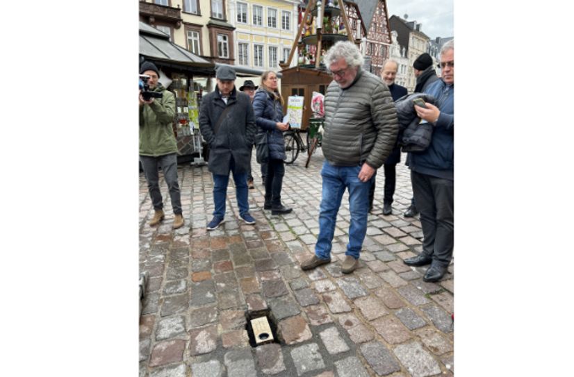 Guy Charlier (rechts) hat die Bronzeplaketten gestaltet. Auf dem Hauptmarkt erinnert nun eine davon an den hier bei der Amokfahrt ermordeten Dr. Georgios Kobiliris. Einge Meter weiter starb bei der noch immer unfassbaren Tat vor drei Jahren auch dessen erst wenige Wochen alte Tochter Virginia