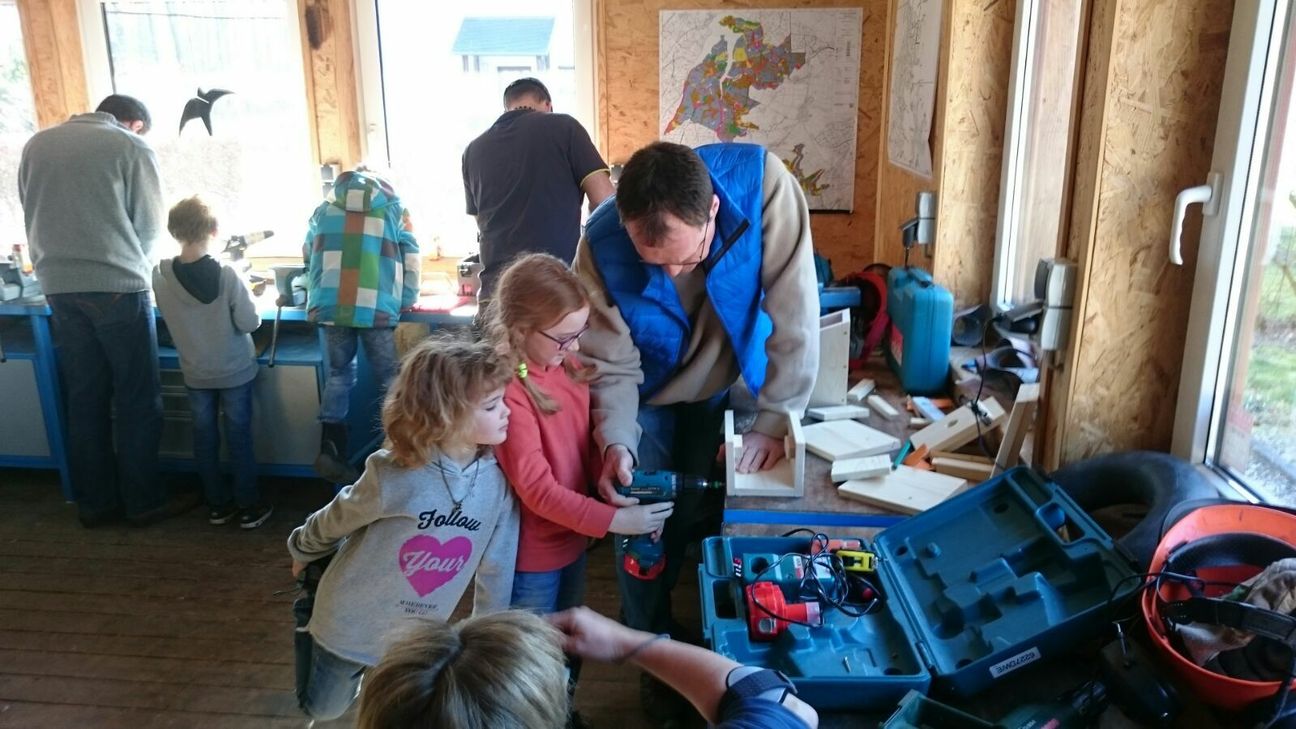 Die Kinder des Eifelvereins Vossenack sind mit ihren Eltern stolz auf die selbst gebauten Nistkästen.