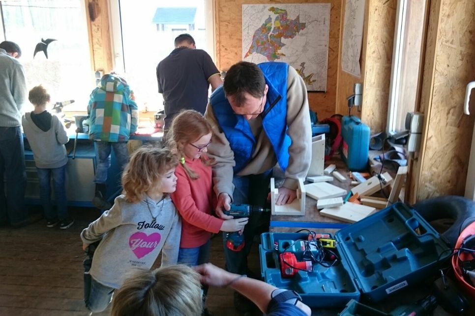 Die Kinder des Eifelvereins Vossenack sind mit ihren Eltern stolz auf die selbst gebauten Nistkästen.