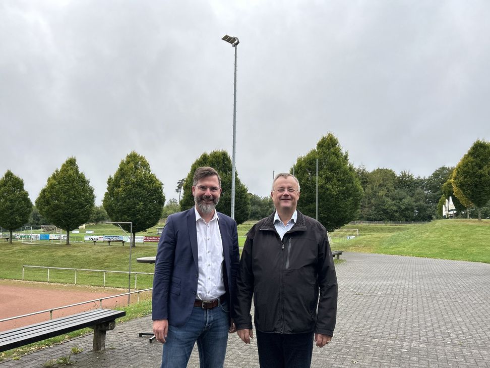 Gemeinsam begutachten (v. l.) Westenergie-Kommunalmanager Christian Nathem und Ortsbürgermeister Markus Franzen die neuen LED-Leuchten auf dem Sportplatz .